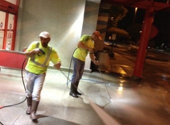 commercial concrete cleaning, night cleaning services, pressure washing commercial building, power washing storefront, exterior building maintenance, retail store cleaning, professional pressure washer, high-visibility clothing, safety gear, night shift cleaning
