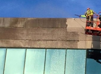 Commercial building exterior being pressure washed