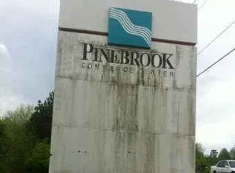 Dirty Pinebrook Commerce Center sign before pressure washing