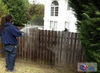 Wooden fence being pressure washed